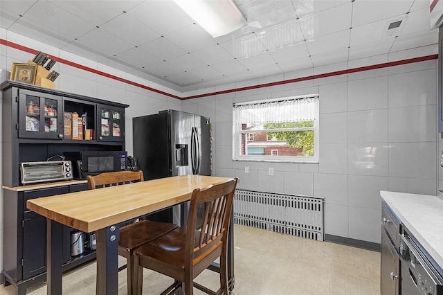 814 Clara St N, Versailles, PA 15137 - dining room featuring a toaster, a drop ceiling, radiator heating unit, and light floors