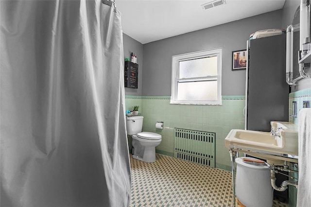 814 Clara St N, Versailles, PA 15137 - bathroom with visible vents, tile walls, a wainscoted wall, toilet, and radiator heating unit