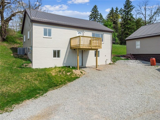 1460 Guffey Rd, North Huntingdon, PA 15642 - back of house with brick siding, a deck, a yard, driveway, and metal roof