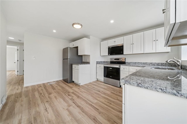 1460 Guffey Rd, North Huntingdon, PA 15642 - kitchen featuring a sink, appliances with stainless steel finishes, light stone countertops, and light wood finished floors
