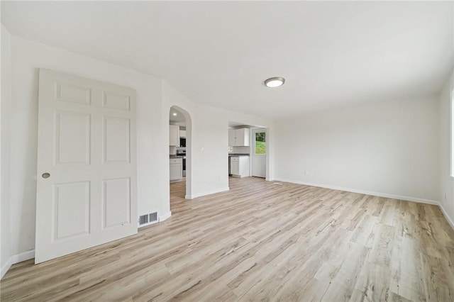 1460 Guffey Rd, North Huntingdon, PA 15642 - unfurnished living room with arched walkways, baseboards, light wood finished floors, and visible vents