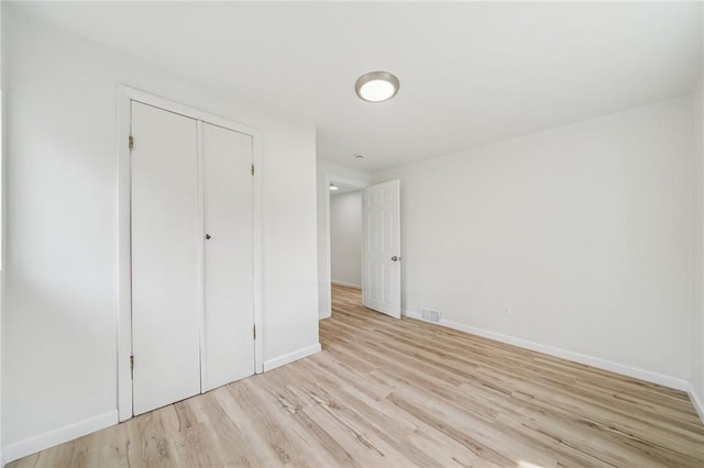 1460 Guffey Rd, North Huntingdon, PA 15642 - unfurnished bedroom with visible vents, light wood-style floors, baseboards, and a closet