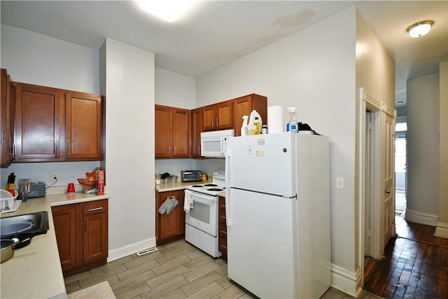kitchen featuring a sink, light countertops, light wood finished floors, and white appliances