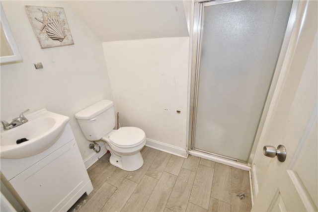 full bathroom with vanity, toilet, baseboards, a shower stall, and wood finished floors