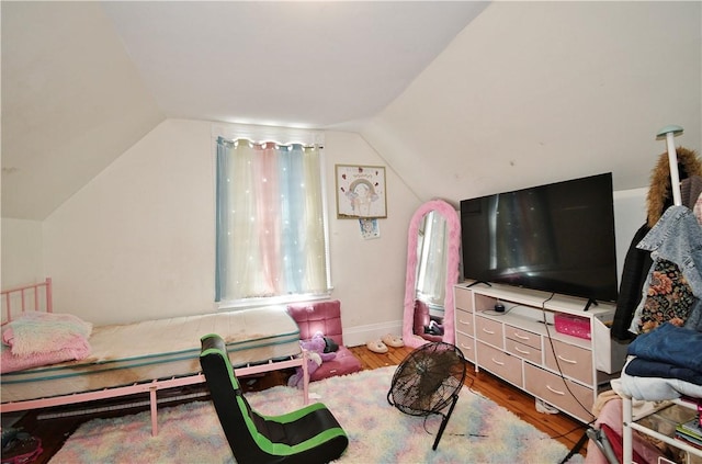 bedroom with baseboards, vaulted ceiling, and wood finished floors
