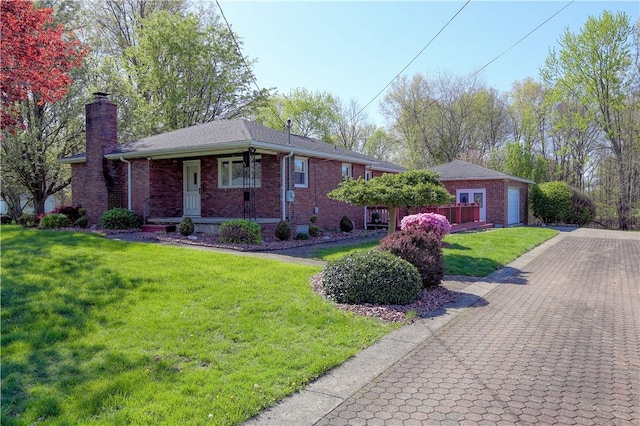 view of front of property featuring a porch, a chimney, a garage, brick siding, and a front lawn