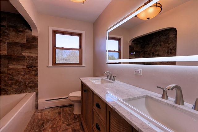 full bathroom with double vanity, toilet, a sink, and baseboard heating