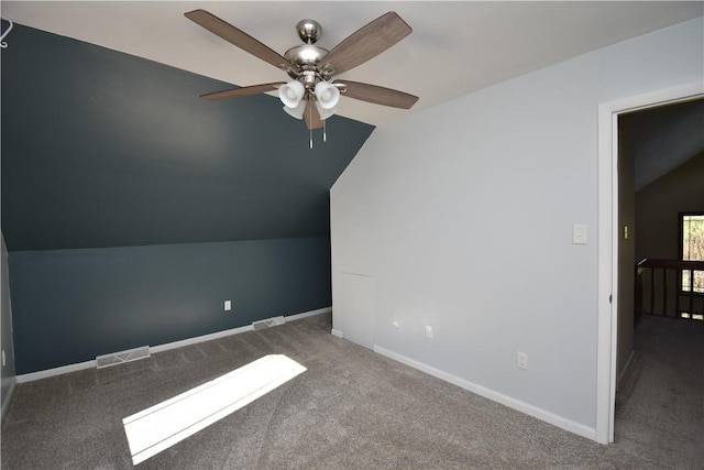 additional living space featuring carpet floors, visible vents, lofted ceiling, baseboards, and ceiling fan