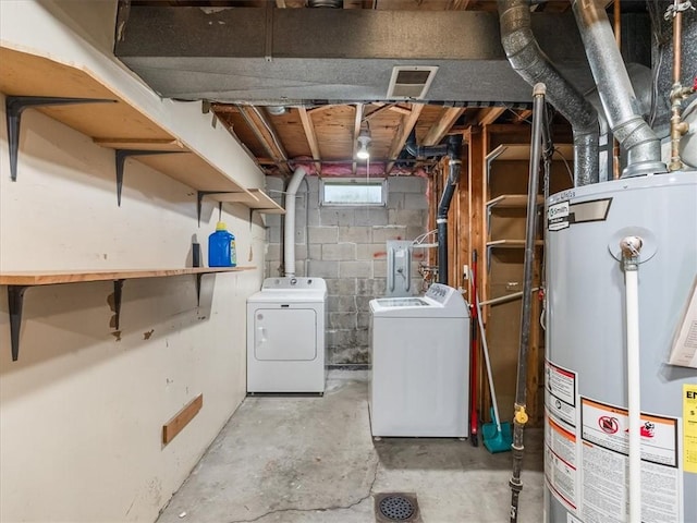 basement with gas water heater, independent washer and dryer, and visible vents