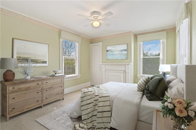 bedroom with a ceiling fan, baseboards, light colored carpet, and multiple windows