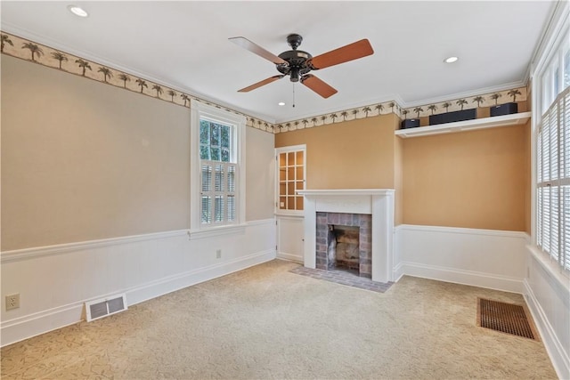 unfurnished living room featuring a ceiling fan, visible vents, and a wealth of natural light