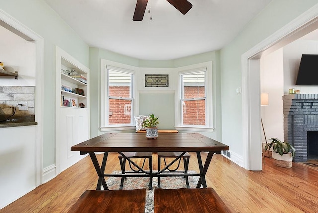 961 Deely St, Greenfield, PA 15217 - dining area featuring a ceiling fan, light wood-type flooring, built in features, and a fireplace