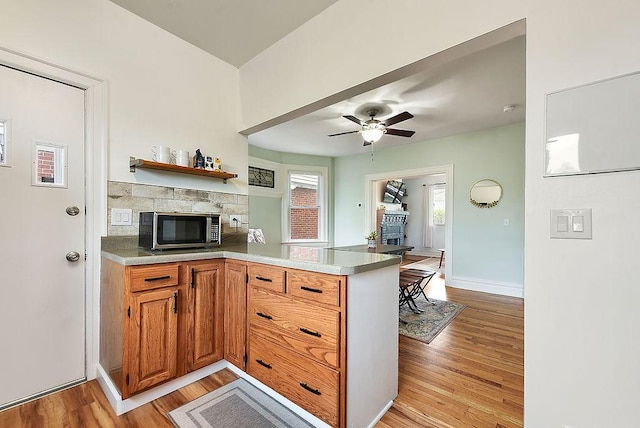961 Deely St, Greenfield, PA 15217 - kitchen featuring ceiling fan, a fireplace, light wood-style flooring, a peninsula, and stainless steel microwave