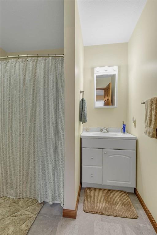 full bathroom with vanity and baseboards