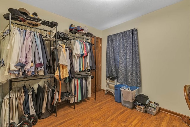 walk in closet with wood finished floors