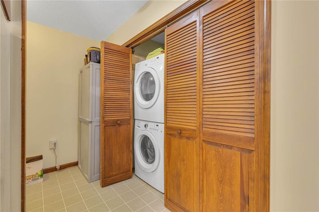 laundry area featuring laundry area, stacked washer / drying machine, and light tile patterned flooring