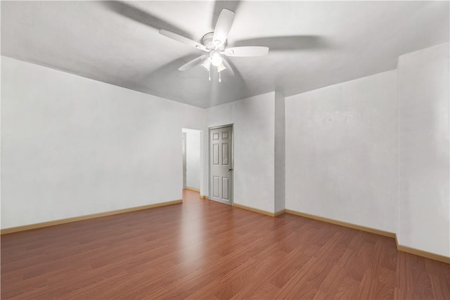 unfurnished room with baseboards, a ceiling fan, and wood finished floors