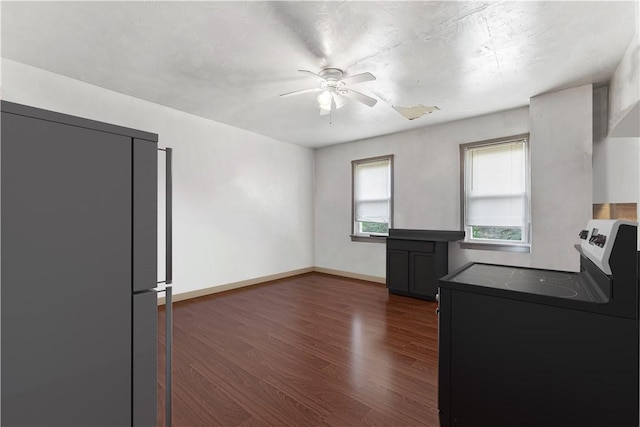 kitchen with fridge, ceiling fan, dark countertops, dark wood finished floors, and washer / clothes dryer