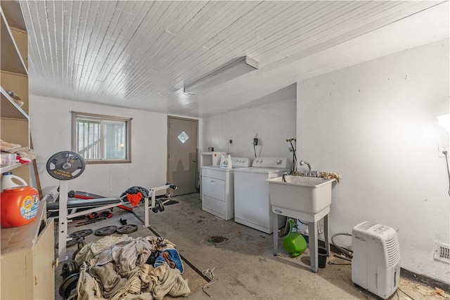 clothes washing area with wooden ceiling and washer and clothes dryer
