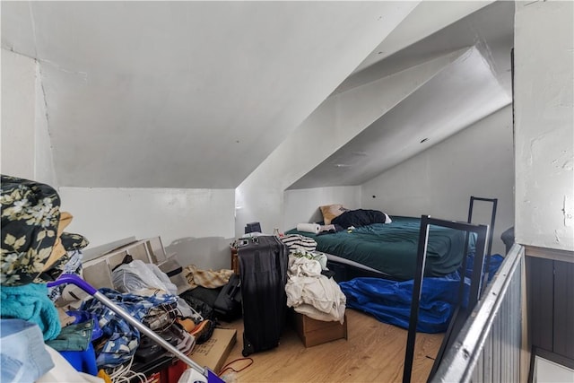 bedroom with lofted ceiling and wood finished floors