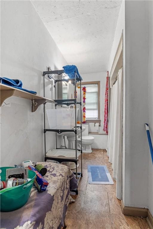 interior space with a shower with shower curtain and toilet