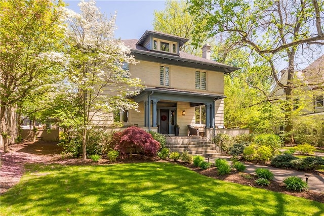 traditional style home with a chimney, a porch, and a front yard