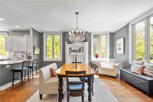 dining room featuring recessed lighting, a notable chandelier, a wealth of natural light, and wood finished floors