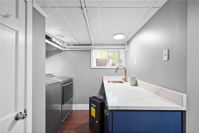 laundry room with dark wood-style flooring, laundry area, a sink, baseboards, and washing machine and dryer