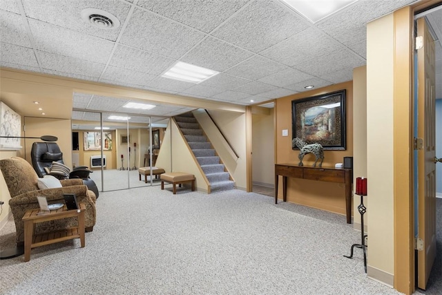 interior space featuring carpet flooring, visible vents, a drop ceiling, and stairway