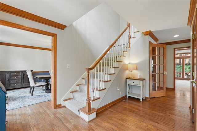 stairway featuring crown molding, baseboards, french doors, and wood finished floors