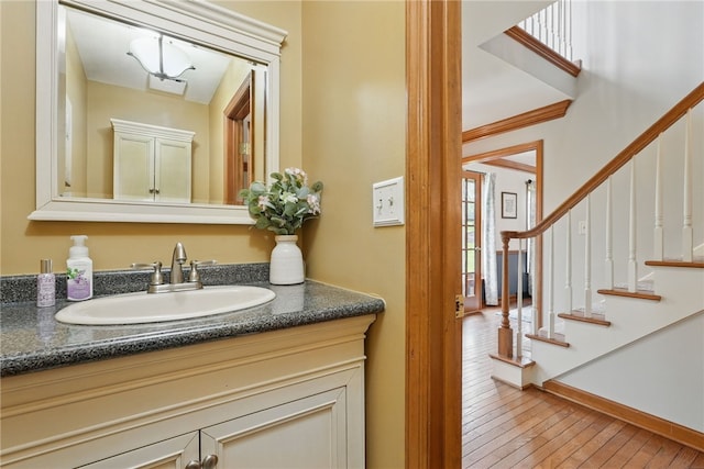 bathroom featuring vanity, baseboards, and hardwood / wood-style flooring