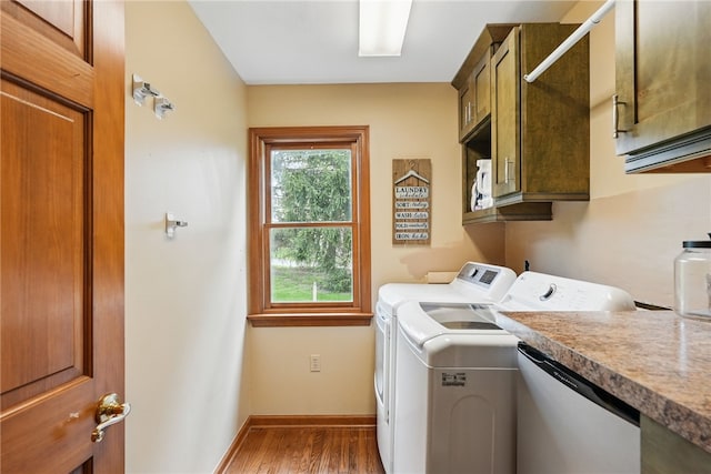 laundry room featuring separate washer and dryer, baseboards, cabinet space, and wood finished floors