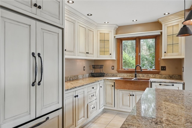 kitchen with light stone counters, recessed lighting, light tile patterned floors, and glass insert cabinets