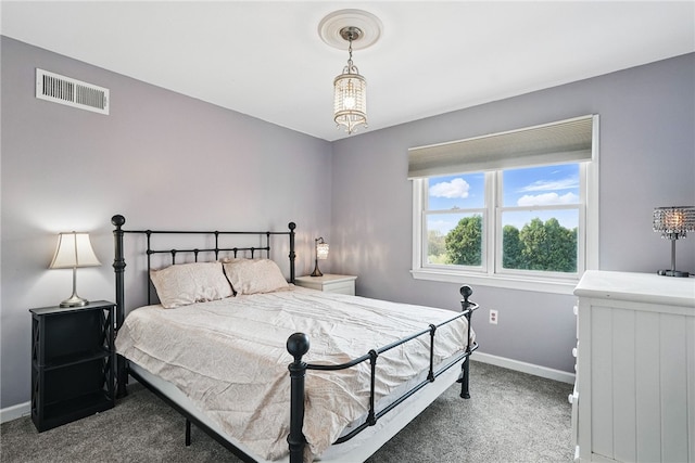 carpeted bedroom with baseboards, a chandelier, and visible vents