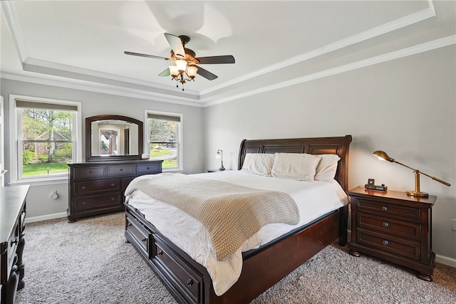 bedroom featuring a raised ceiling, baseboards, and light carpet