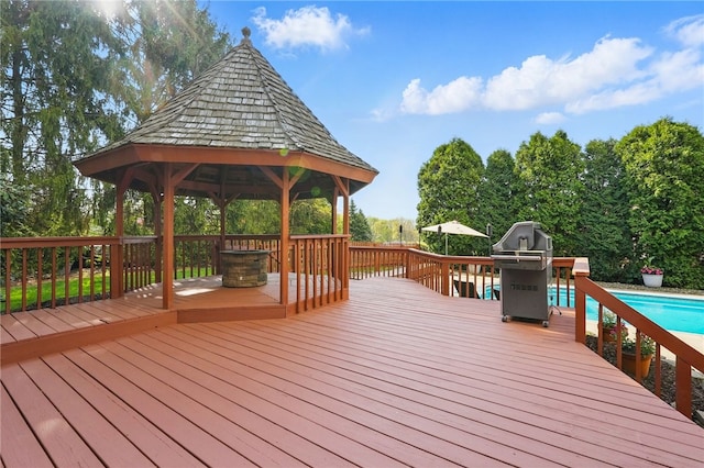 wooden terrace featuring grilling area, a gazebo, and an outdoor pool