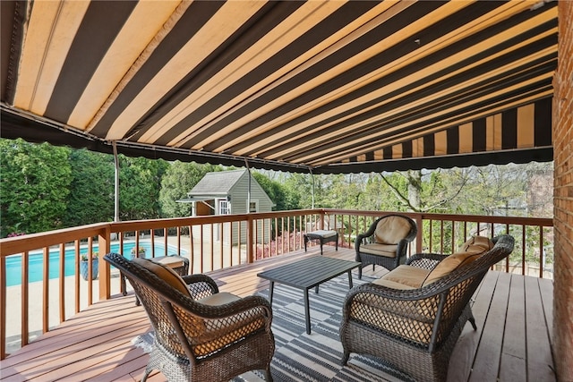 deck featuring an outdoor structure, an outdoor living space, and an outdoor pool