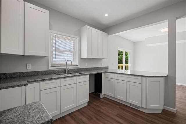 25 Scotia St, Ingram, PA 15205 - kitchen featuring dark wood-type flooring, a sink, dark stone counters, and a peninsula