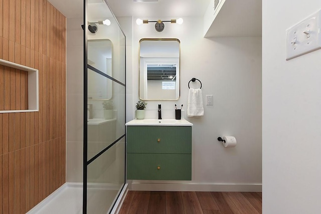 full bathroom featuring vanity, baseboards, walk in shower, and wood finished floors