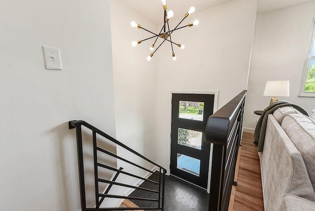 foyer with baseboards, a wealth of natural light, wood finished floors, and a chandelier