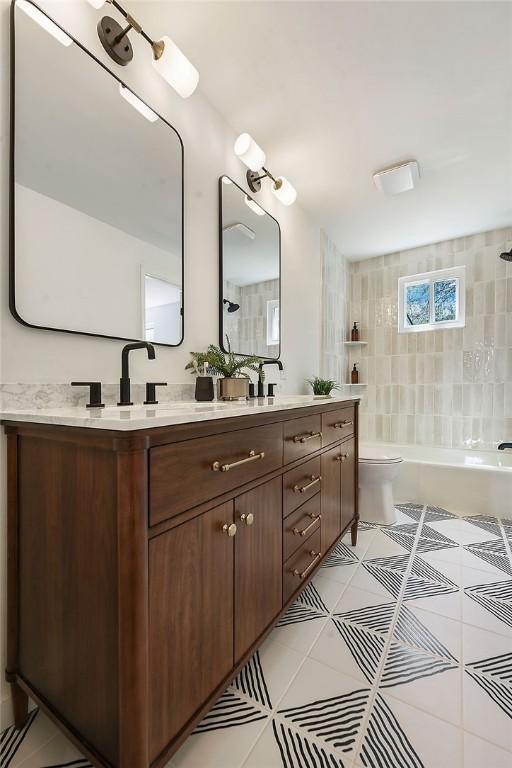 bathroom with double vanity, tile patterned floors, bathtub / shower combination, and toilet