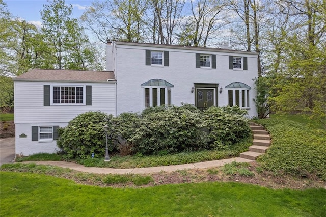 view of front of house with a front yard and a chimney