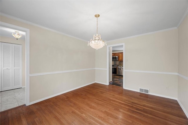 unfurnished dining area with visible vents, wood finished floors, baseboards, a notable chandelier, and ornamental molding
