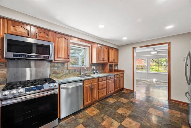 kitchen with baseboards, recessed lighting, a sink, backsplash, and stainless steel appliances