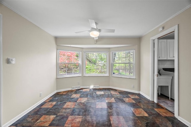 interior space featuring stone finish floor, baseboards, a ceiling fan, and visible vents