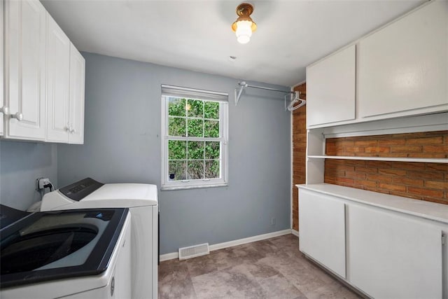 clothes washing area featuring separate washer and dryer, cabinet space, baseboards, and visible vents
