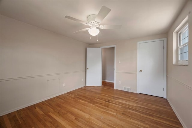 unfurnished bedroom with baseboards, ceiling fan, light wood-type flooring, and visible vents