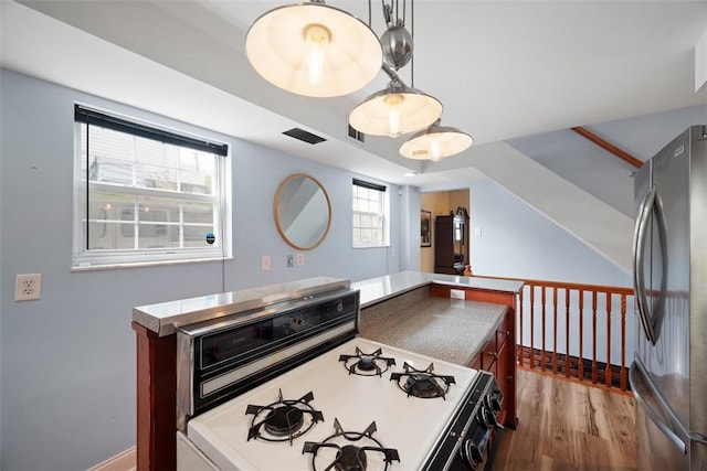 1928 Shamokin, South Side, PA 15203 - kitchen with freestanding refrigerator, white range with gas stovetop, wood finished floors, and decorative light fixtures