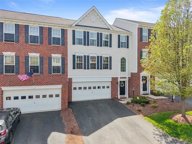 view of property featuring brick siding, a garage, and driveway