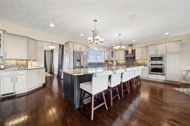 1043 Blackthorne Dr, Penn Twp Wml, PA 15644 - kitchen featuring decorative backsplash, a large island, an inviting chandelier, stainless steel appliances, and wall chimney exhaust hood